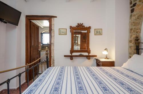 a bedroom with a bed and a mirror at Venetiko Apartments in Naxos Chora