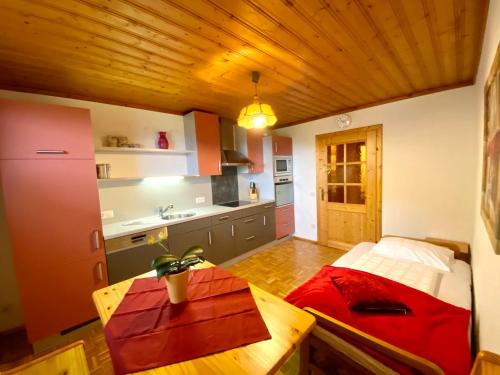 a kitchen with a table and a bed in a room at Pleschinhof in Velden am Wörthersee