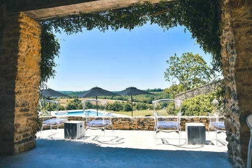 a view of a patio with chairs and a pool at Le Mas & Le Mazet in Sainte-Croix-de-Beaumont