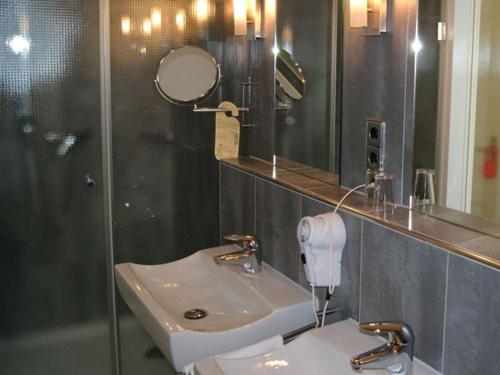 a bathroom with a sink and a mirror at Hotel Rauch in Attendorn