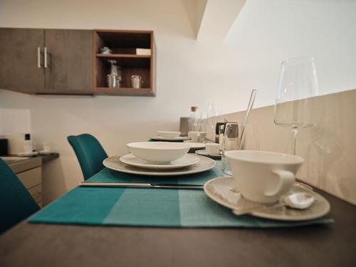 a table with plates and cups on top of it at SEE Moment Appartements ADULTS ONLY in St. Wolfgang