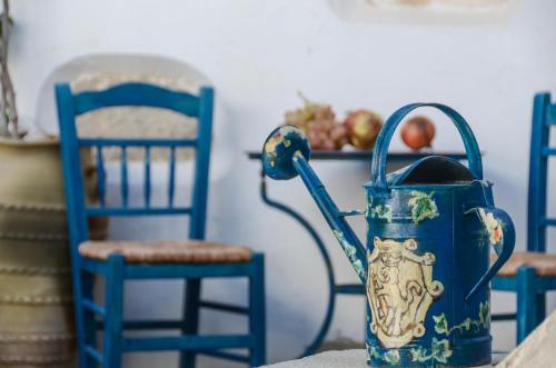 a blue vase sitting on a table with blue chairs at Venetiko Apartments in Naxos Chora
