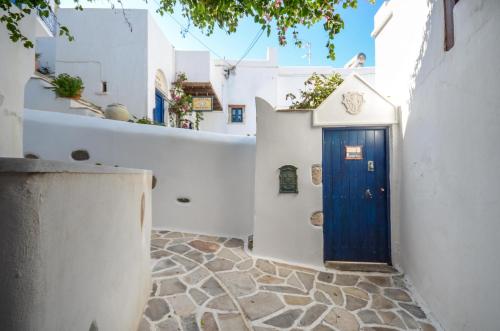 a blue door in a white building with a walkway at Venetiko Apartments in Naxos Chora