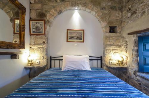 a bedroom with a bed in a stone wall at Venetiko Apartments in Naxos Chora