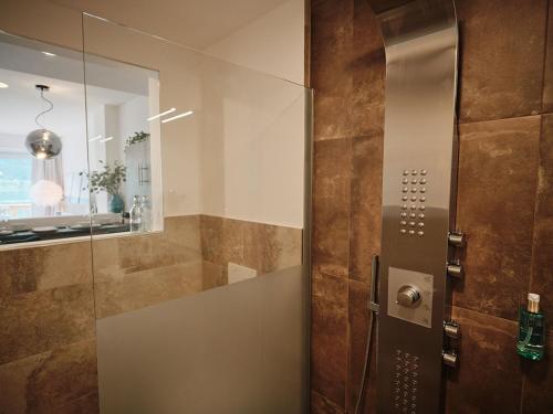 a bathroom with a shower with a glass door at SEE Moment Appartements ADULTS ONLY in St. Wolfgang