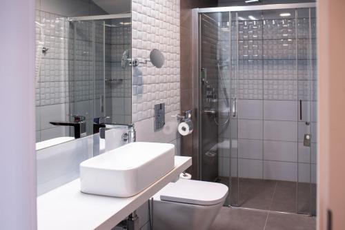 a bathroom with a sink and a toilet and a shower at Hotel TAMMEL in Jičín