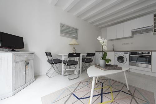 Il comprend un salon blanc avec une table et une cuisine. dans l'établissement Nieve, à Paris