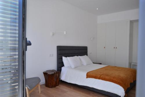 1 dormitorio con 1 cama grande y suelo de madera en HOTEL S - ALOJAMENTO LOCAL, en Castro Verde