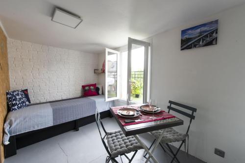 um quarto com uma cama, uma mesa e cadeiras em Piaf em Paris