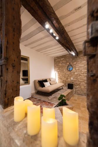 - un salon avec un canapé et des bougies jaunes dans l'établissement Pierre à Feu, à Paris