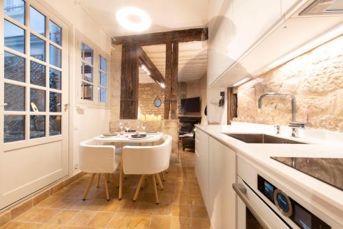 cocina con fregadero, mesa y sillas en Pierre à Feu, en París