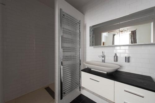 une salle de bain blanche avec un lavabo et un miroir dans l'établissement Songe, à Paris