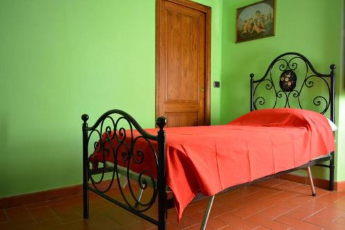 a green bedroom with a bed with a red blanket at Casa Furielli in Radda in Chianti