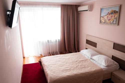 a hotel room with a bed and a window at Hotel Halychyna in Ternopilʼ