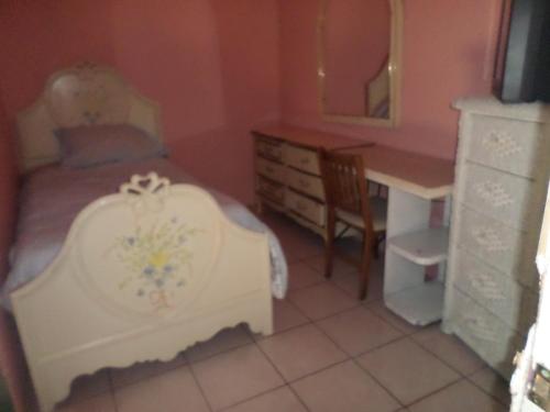 a bedroom with a bed and a desk and a mirror at Hospedaje Barato Mi Casita de Colores in Tijuana