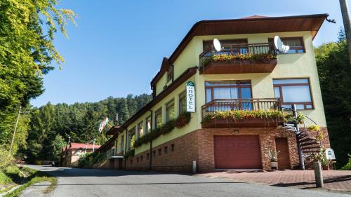 ein Gebäude mit Blumen auf den Balkonen an einer Straße in der Unterkunft Hotel Šomka in Drienica