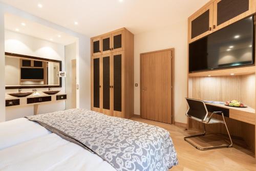 a bedroom with a bed and a desk with a computer at Residenz Alte Post Bonaduz in Bonaduz