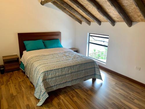 1 dormitorio con 1 cama en una habitación con ventana en Bellísimo chalet en Zona Colonial (301), en Zipaquirá