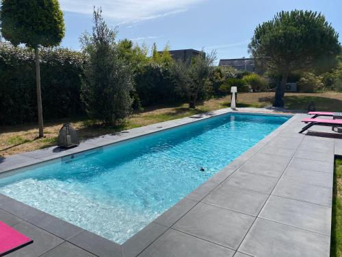 une piscine avec de l'eau bleue dans une cour dans l'établissement LES EVENS La Baule, à La Baule