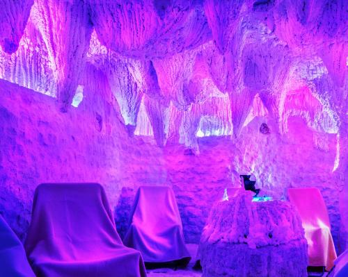 a room with pink lights and chairs and a table at Reitenberger Spa Medical in Mariánské Lázně