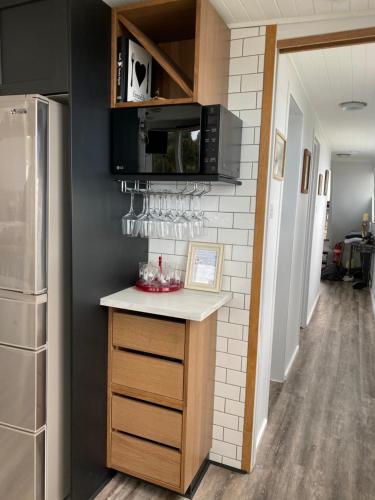 a kitchen with a counter with a microwave and a refrigerator at Swamp Fox luxury 2BR Dutch Barge in Goolwa