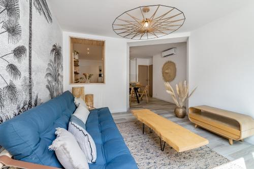 un salon avec un canapé bleu et une table dans l'établissement Le Zòu par Dodo-a-Cassis, à Cassis