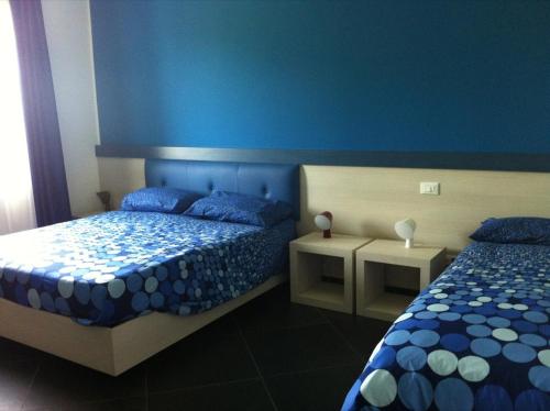 a bedroom with two beds and a blue wall at Campo Allegro in Santa Ninfa
