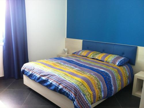 a bedroom with a bed with a blue wall at Campo Allegro in Santa Ninfa