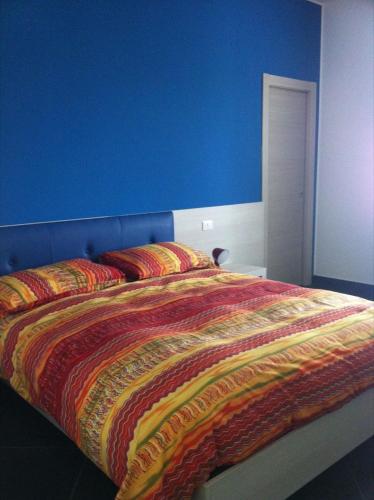 a blue bedroom with a bed with a colorful blanket at Campo Allegro in Santa Ninfa