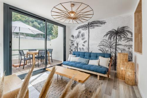 un salon avec un canapé bleu et une table dans l'établissement Le Zòu par Dodo-a-Cassis, à Cassis