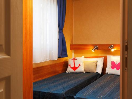 two beds in a room with a window at Portofelice Camping Village in Eraclea Mare