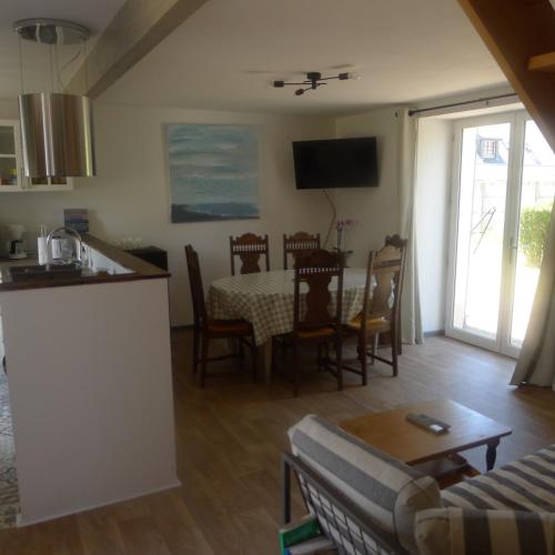 une cuisine et un salon avec une table et des chaises dans l'établissement Ty Bétahon - 200m de la plage, à Ambon