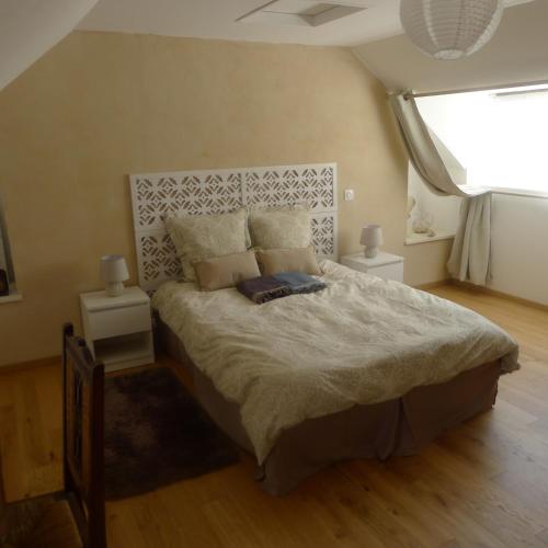 une chambre avec un grand lit avec deux tables de nuit dans l'établissement Ty Bétahon - 200m de la plage, à Ambon