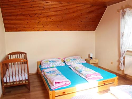 1 dormitorio con cama y techo de madera en Chalupa Denis & Marek, en Kovářská