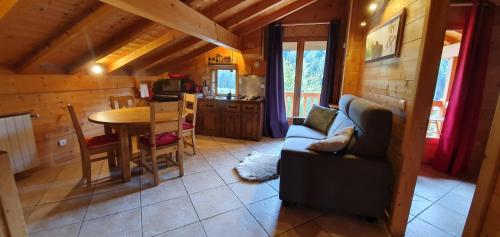 - un salon avec un canapé et une table dans une cabine dans l'établissement Bienvenue dans notre chalet! Appartement Les Sitelles, au Grand-Bornand