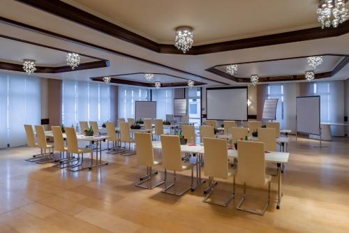 a conference room with tables and chairs in it at Arthotel ANA Style Augsburg in Augsburg