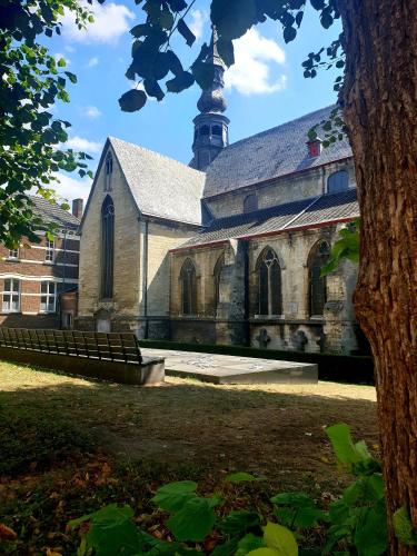 a church with a clock tower in the background at Het Begijnhof Tongeren Center in Tongeren