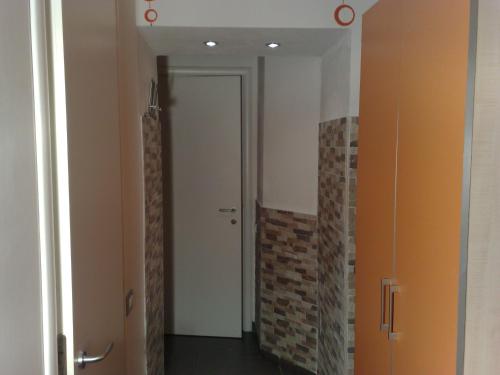 un couloir avec une porte blanche et un mur en briques dans l'établissement B&b Centrale, à Matera