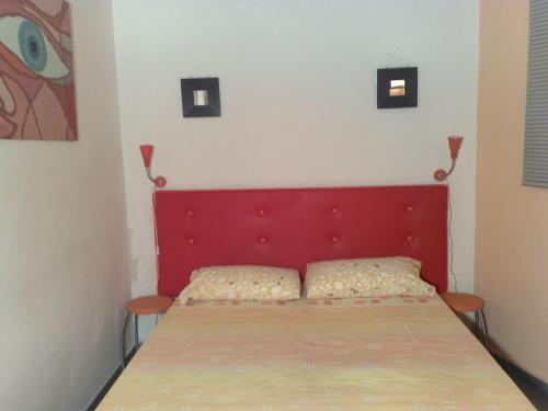 un letto con testiera rossa in una stanza di B&b Centrale a Matera