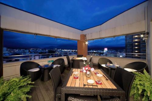 una mesa en un balcón con vistas a la ciudad en Hatago Hashimoto, en Ozu