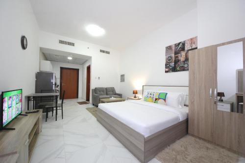 a bedroom with a bed and a living room at SHH - Furnished Studio in Palace Tower 2, Silicon Oasis in Dubai