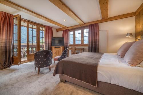 a bedroom with a large bed and a television at Auberge du Bois Prin in Chamonix