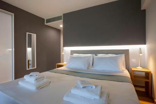 a bedroom with a bed with two towels on it at Athens Panorama Project in Athens