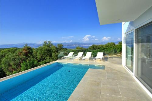 a swimming pool on the side of a house at Villa Nafsika by PosarelliVillas in Perítheia