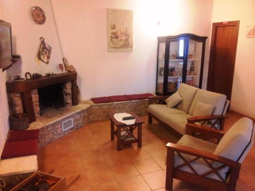 ein Wohnzimmer mit einem Sofa und einem Kamin in der Unterkunft Casale Corcella in Scopello