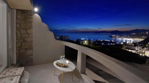 a balcony with a view of the ocean at night at Crystal Suites in Mýkonos City