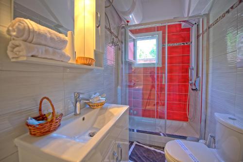 a bathroom with a sink and a shower and a toilet at Villa Giador by PosarelliVillas in Perítheia