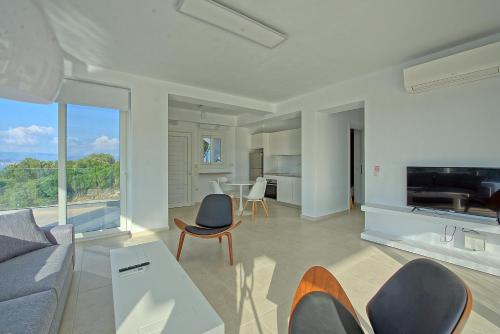 a living room with a couch and a table at Villa Nafsika by PosarelliVillas in Perítheia