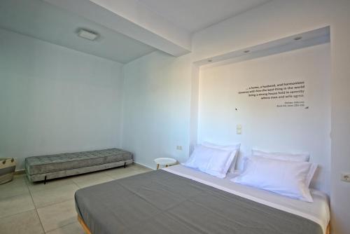 a bedroom with a bed and a wall with writing on it at Villa Nafsika by PosarelliVillas in Perítheia