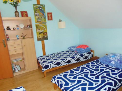 a bedroom with two beds and a dresser at Gospodarstwo Agroturystyczne Lucynka in Urszulin